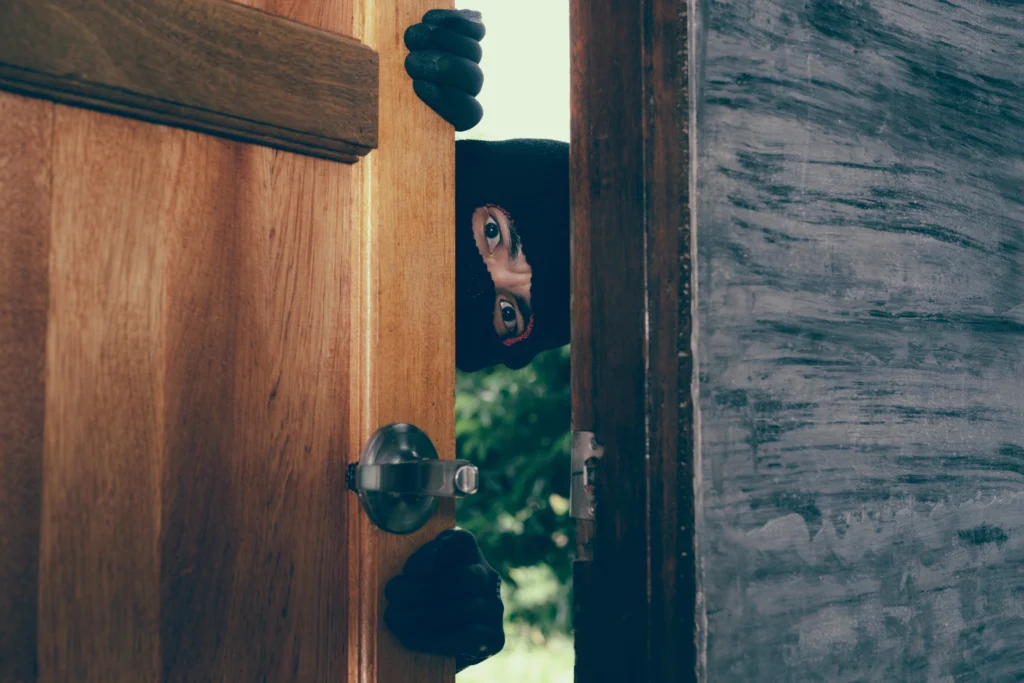 Persoon kijkt door opening van deur tijdens veiligheidscheck.